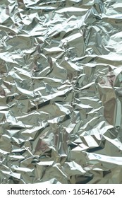 Metallic foil texture. Metallic background. Metal glittering, crushed, glister surface, backdrop. Crumpled texture. Reflective surface. Folded, rumpled or creased background. Vector illustration