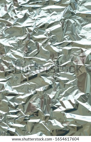 Metallic foil texture. Metallic background. Metal glittering, crushed, glister surface, backdrop. Crumpled texture. Reflective surface. Folded, rumpled or creased background. Vector illustration