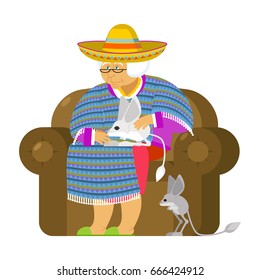 Mexican grandmother and Jerboa a pet. Old woman from Mexico on chair. Sombrero and poncho. Traditional clothes
