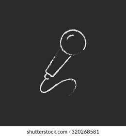 Mano de micrófono dibujada con tiza en un icono blanco vectorial de pizarra aislado en un fondo negro.
