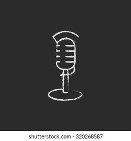 Microphone hand drawn in chalk on a blackboard vector white icon isolated on a black background.