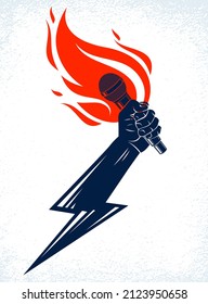 Microphone in hand on fire and lightning, hot mic in flames and bolt, rap battle rhymes music, concert festival or night club label, karaoke singing or standup comedy, vector logo.