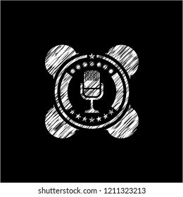 microphone icon inside chalkboard emblem on black board