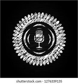 microphone icon inside chalkboard emblem on black board