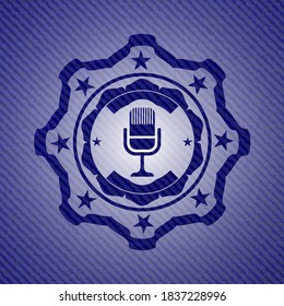 icono de micrófono dentro del emblema con fondo de alta calidad de denim. 