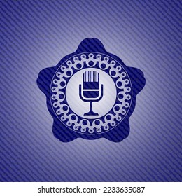 icono de micrófono dentro del emblema con fondo de jean. 