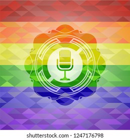 microphone icon inside emblem on mosaic background with the colors of the LGBT flag
