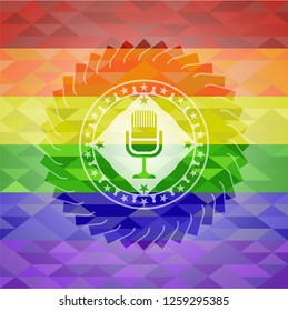 microphone icon inside emblem on mosaic background with the colors of the LGBT flag