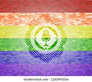 microphone icon inside emblem on mosaic background with the colors of the LGBT flag