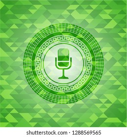 microphone icon inside green emblem with triangle mosaic background