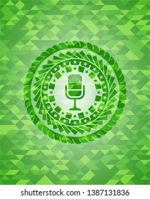 microphone icon inside green mosaic emblem