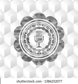 microphone icon inside grey emblem with geometric cube white background