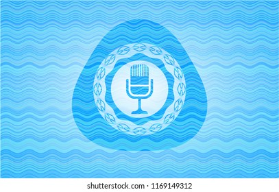 microphone icon inside light blue water style badge.