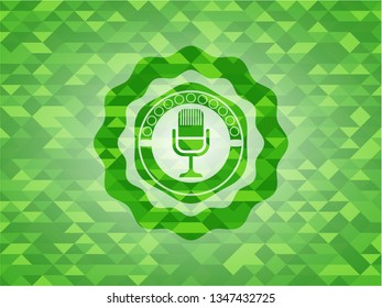 microphone icon inside realistic green emblem. Mosaic background