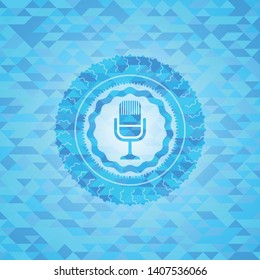 microphone icon inside realistic light blue emblem. Mosaic background