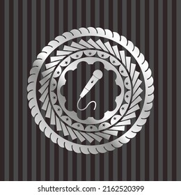 Mikrofon-Symbol in silberglänzendem Abzeichen. 