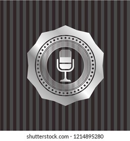 microphone icon inside silvery emblem or badge
