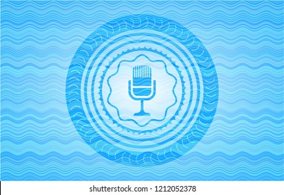  microphone icon inside sky blue water wave badge.