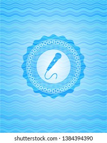 microphone icon inside sky blue water wave badge background.