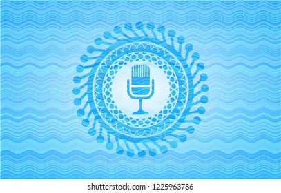 microphone icon inside water concept emblem.