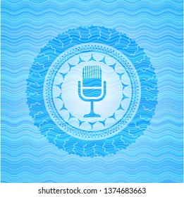 microphone icon inside water concept style emblem.