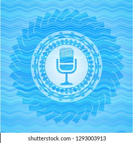 microphone icon inside water representation style emblem.