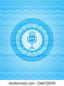 microphone icon inside water representation emblem.