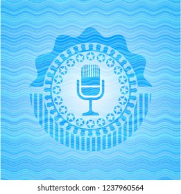 microphone icon inside water wave style emblem.