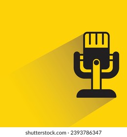 micrófono en el icono de la base con sombra en el fondo amarillo