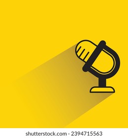 Mikrofon auf Standsymbol mit Schatten auf gelbem Hintergrund