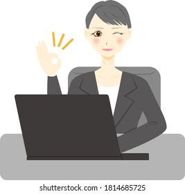 Middle aged woman using computer. OK sign. 