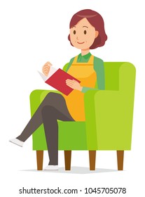 A middle-aged housewife wearing an apron is reading on a sofa