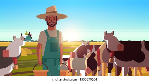 milkman holding buckets with fresh milk farmer standing near herd of cows grazing on grassy field eco farming husbandry concept sunset landscape background closeup horizontal portrait vector