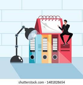 mini businessman sitting in books in the workplace
