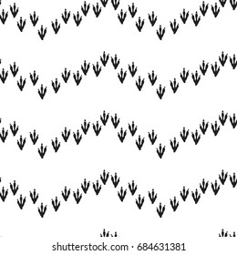 Minimal seamless pattern with dinosaur foots. Black and white colors. Vector illustration.