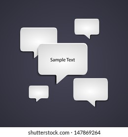 Minimalist Speech Bubble Layout – White Dialog Icons on Dark Background with Sample Text. A clean and modern graphic layout featuring five white speech bubbles of varying sizes scattered across a dark background. The central bubble contains the phrase “Sample Text,” while the others remain blank, allowing for customization. This minimalist and stylized composition is ideal for use in communication-themed visuals, presentations, digital media, and editorial layouts. Suitable for both commercial and editorial use across print and digital platforms.