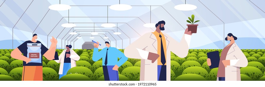mix race agricultural engineers researching plants in greenhouse agriculture scientist smart farming