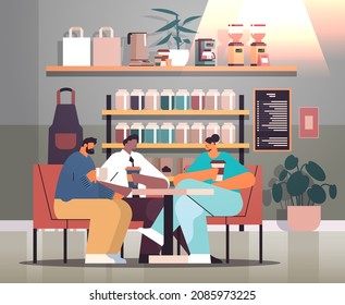 mix race businesspeople sitting at cafe table and drinking coffee during meeting modern cafeteria interior
