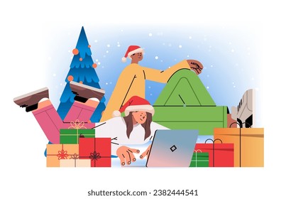 mix race man woman in santa hats near decorated christmas tree using laptop social media communication new year holidays celebration