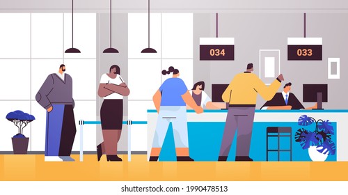 mix race people looking at display number board in waiting room with ticket system electronic queuing system