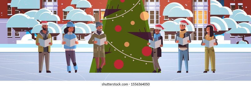 mix race people reading books merry christmas happy new year holiday celebration concept men women wearing santa hats standing near fit tree modern cityscape background horizontal full length vector