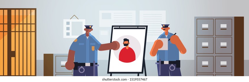 mix race policemen officers couple looking at board with thief photo security authority justice law service concept modern police department interior flat portrait horizontal