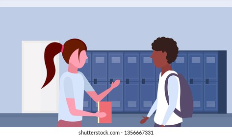 mix race pupils couple discussing in school lobby corridor interior with row of blue lockers communication education concept horizontal portrait flat