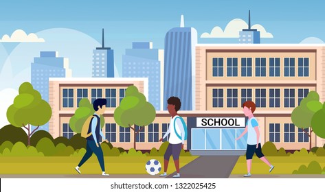 mix race schoolgirls playing football in front of school building primary schoolchildren having fun back to school concept cityscape background flat full length horizontal