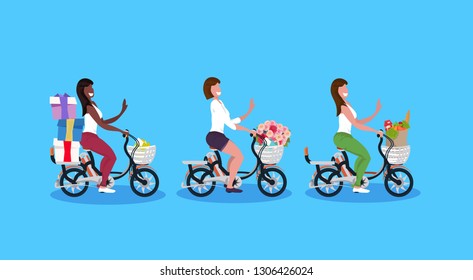 mix race women cycling bicycle carrying gift boxes flowers bouquet grocery bag holiday activity concept girls riding bike female cartoon characters full length horizontal flat