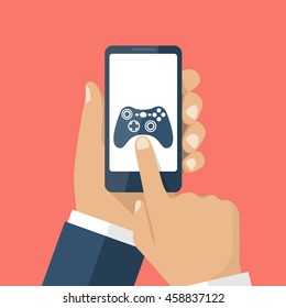 Mobile game concept. Hand holding smartphone, with gaming application on screen. Vector illustration flat design. Icon joystick, controller. Touching finger to display.