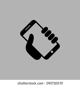 Mobile phone in hand icon. Isolated on gray background
