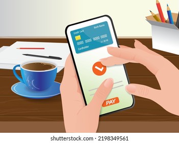 A mobile phone, on the screen of which there is a bank card and a PAY button in female hands on the background of a workplace in an office or at home. Mobile payment concept.