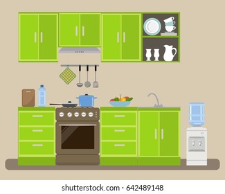 Modern kitchen in a green color. There is a kitchen furniture, a stove, a water cooler and other objects in the picture. On the table is a plate of vegetables. Vector flat illustration.