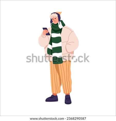 Modern man in winter clothes, holding mobile phone in hand. Young stylish guy with smartphone, wearing fashion apparel, warm jacket, scarf, hat. Flat vector illustration isolated on white background